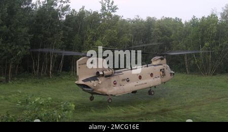 Ein Hubschrauber der New York Army National Guard CH-47 von B Company, 3. Bataillon, 126. Luftfahrtregiment landet auf einem Trainingsgelände während einer Übung in Fort Drum, Juni 30. Während des Trainings besetzten und verteidigten Soldaten des 1. Bataillons das 69. Infanterie-Regiment eine Position gegen eine feindliche Truppe. Das 69. Regiment führt in Fort Drum ein Prämobilisationstraining durch, um einen bevorstehenden Einsatz am Horn von Afrika vorzubereiten. Stockfoto