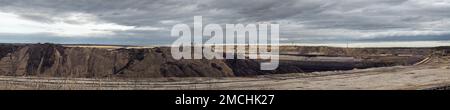 Landschaft einer Braunkohlemine. Panorama der offenen Grube in Sachsen. Die umgewandelte und zerstörte Natur, um die Braunkohlevorkommen zu nutzen. Totes Ödland. Stockfoto