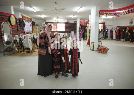 Gaza, Palästina. 19. Januar 2023. Suhaila Shaheen, 60, streichelt ihre Enkelkinder in ihrem eigenen Museum in Rafah, südlich des Gazastreifens. Eine palästinensische Frau Suhaila Shaheen, 60, gründete ein Museum zum Kulturerbe, das die Sammlungen, die sie gesammelt hat, und das, was sie auf ihre Kosten gekauft hat, enthält. Um das Ziel zu erreichen, das erste Museum mit dem Namen seiner Stadt, Rafah, zu errichten. Kredit: SOPA Images Limited/Alamy Live News Stockfoto