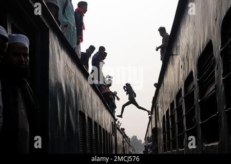 Dhaka, Bangladesch. 22. Januar 2023. Pendler springen nach der Ankunft an einem Bahnhof zwischen den Zügen, um Akheri Munajat zu besuchen, die letzte Bitten während Biswa Ijtema in Tongi, Dhaka, Bangladesch. Millionen muslimischer Anhänger aus der ganzen Welt nehmen an dem viertägigen Ereignis Teil, das im Akheri Munajat gipfelt, oder dem abschließenden Bitten (Schlussplädoyer), in dem muslime vor Allah die Hand heben und für den Weltfrieden beten. Es ist die zweitgrößte Gemeinde der muslimischen Gemeinde nach der Pilgerfahrt nach Mekka für den Hajj. Kredit: Joy Saha/Alamy Live News Stockfoto