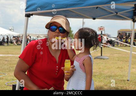 Rylie Kohama, 3, bläst mit ihrer Mutter Rose Kohama am 4. Juli auf dem Feld der Division Parade während des Unabhängigkeitstages in Fort Campbell Blasen. Die Family Fun Zone der Veranstaltung erwies sich dank der Schlauchboote, der Spiele auf dem Hof und der Food Trucks als ein Hit für Kinder. Stockfoto