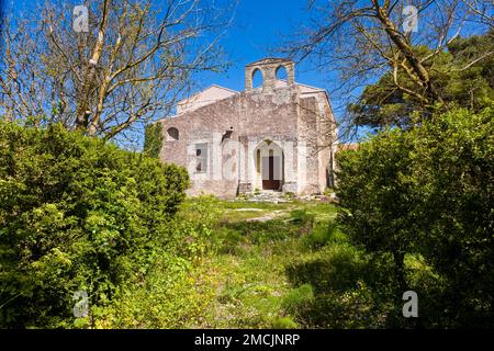 Das Gebäude der Kirche Chiesa di Sant'Antonio Abate befindet sich in einem kleinen Garten mit Bäumen und Büschen. Stockfoto