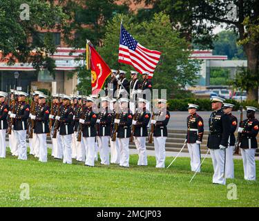 Marines bei den offiziellen US-Marines Marine Corps Color Guard präsentiert die US-Flagge während einer Sunset Parade am Marine Corps war Memorial, Arlington, Virginia, 5. Juli 2022. Gastgeber des Abends war General Mark H. Clingan, stellvertretender Kommandant, Kampfentwicklung und -Integration, und Oberstleutnant Joseph Shusko, United States Marine Corps (Ret.), der Ehrengast. Stockfoto