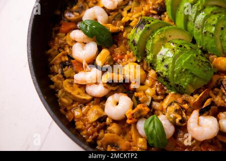 Meeresfrüchte-Paella mit Garnelen und Avocado. Authentisches spanisches Paella-Rezept. Stockfoto