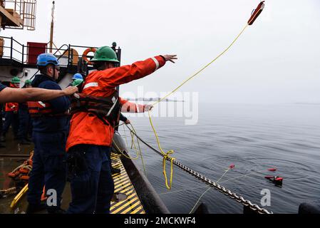 Petty Officer 2. Class Zacharia Summerall wirft eine Schwerlinie zu einer simulierten Person in Not vor der USCGC Oak (WLM 211) nahe Nuuk, Grönland, 6. Juli 2022. Die Mann-über-Bord-Übung ist Teil der jährlich stattfindenden Trainingsveranstaltung Argus, die die Fähigkeiten internationaler Partner bei der Reaktion auf Such- und Rettungsaktionen sowie Meeresumweltereignisse in der Arktis verbessern soll. USA Foto der Küstenwache von Petty Officer 2. Klasse Diana Sherbs. Stockfoto