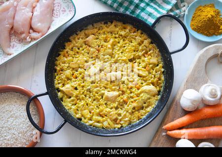 Hähnchen-Curry-Paella mit Gemüse. Authentisches spanisches Paella-Rezept. Stockfoto