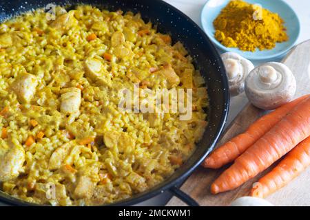 Hähnchen-Curry-Paella mit Gemüse. Authentisches spanisches Paella-Rezept. Stockfoto