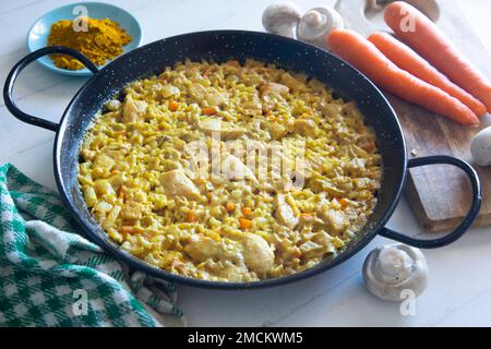 Hähnchen-Curry-Paella mit Gemüse. Authentisches spanisches Paella-Rezept. Stockfoto