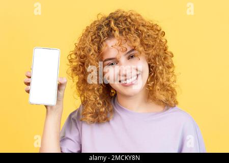 Smiley-Frau hält ein Handy mit einem leeren Bildschirm Stockfoto