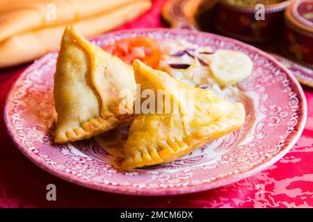 Samosa ist ein gebratener oder gebackener Teig mit herzhafter Füllung, z. B. gewürzte Kartoffeln, Zwiebeln, Erbsen, Fleisch oder Linsen. Traditionelle Indische Küche. Stockfoto