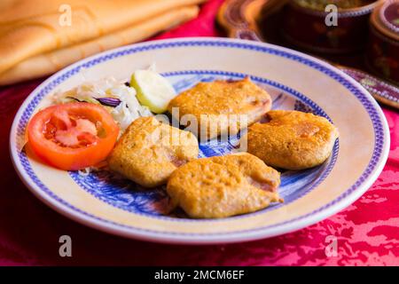 Samosa ist ein gebratener oder gebackener Teig mit herzhafter Füllung, z. B. gewürzte Kartoffeln, Zwiebeln, Erbsen, Fleisch oder Linsen. Traditionelle Indische Küche. Stockfoto