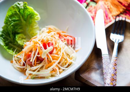 Grüner Papayasalat ist ein würziger Salat aus geriebener grüner Papaya. Stockfoto