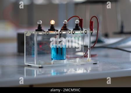 Elektrolytlösung schaltet eine Glühlampe ein. Experiment im Chemielabor Stockfoto