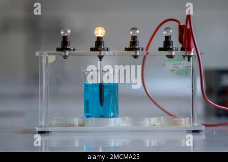 Elektrolytlösung schaltet eine Glühlampe ein. Experiment im Chemielabor Stockfoto