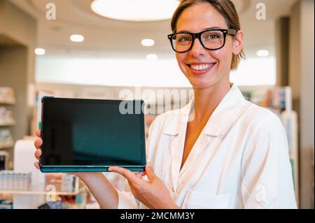 Eine Apothekerin prüft Informationen zu Arzneimitteln auf der Tablette Stockfoto