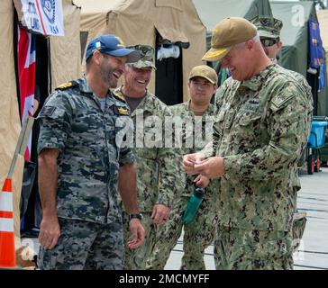 220707-N-PQ495-1205 SAN DIEGO - (7. Juli 2022) – Rear ADM. Christopher Alexander, Commander, Combined Task Force 177, Right, lacht über ein Münzdesign mit dem Royal Australian Navy LT. Commander. Andrew William Thomas, kommandierender Offizier des Australian Clearance Diving Teams 4. Von Juni 29 bis August 4 nehmen an der RIMPAC 25.000 Nationen, 38 Schiffe, vier U-Boote, mehr als 170 Flugzeuge und Mitarbeiter auf und um die hawaiianischen Inseln und Südkalifornien Teil. RIMPAC ist die weltweit größte internationale Seefahrt-Übung und bietet eine einzigartige Ausbildungsmöglichkeit bei gleichzeitiger Förderung von und Stockfoto