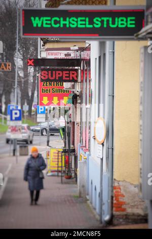 Slubice, Polen. 18. Januar 2023. Eine Frau geht an einem Zigarettenladen vorbei, in der Nähe von Simon, in Richtung einer Wechselstube. Kredit: Soeren Stache/dpa/Alamy Live News Stockfoto