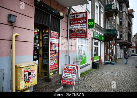 Slubice, Polen. 18. Januar 2023. Ein Mann geht an einem Wohn- und Geschäftsgebäude in der Innenstadt vorbei und geht zu einem Laden, der Feuerwerk und Zigaretten verkauft. Kredit: Soeren Stache/dpa/Alamy Live News Stockfoto