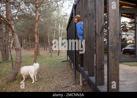 Die Frau ruht in der Nähe einer hölzernen Hütte in der Natur Stockfoto