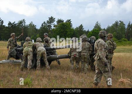 USA Fallschirmjäger, die einer Batterie zugeteilt sind, 4. Bataillon, 319. Artillerie-Regiment, 173. Brigade, stellen einen M119A3-Haubitzer auf dem Grafenwoehr-Trainingsgelände, Deutschland, am 7. Juli 2022 auf. Stockfoto