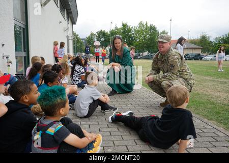 WIESBADEN, Deutschland – Staff Sgt. Mathew Dobson (rechts) von der 525. Militärpolizei und Kori Lekar (links), Training and Curriculum Specialist des Schulalterszentrums in Clay Kaserne, beantwortet Fragen von Kindern während einer Demonstration mit arbeitenden Hunden auf Hainerberg. (Foto von Roland Schedel, USAG Wiesbaden Public Affairs Office) Stockfoto