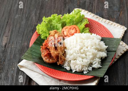 Nasi Ayam Geprek Sambal Bawang, Weißreis mit knusprigem gebratenem Huhn und würziger Knoblauchsauce. Stockfoto