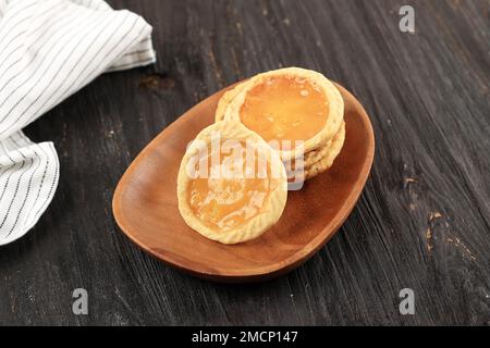 Pie Susu Bali, Custard Tart oder Milk Pie. Serviert auf einem Holztisch Stockfoto