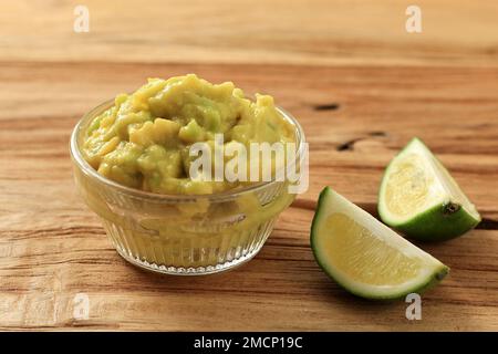 Eine Schüssel Guacamole Avocado Sauce mit Holzhintergrund, Nahaufnahme Stockfoto