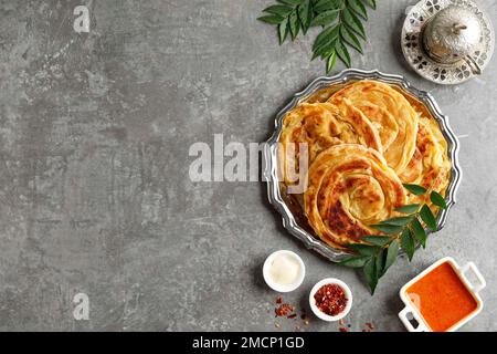 Roti Parata oder Roti Canai mit Lamm-Curry-Sauce und Joghurt. Draufsicht, Bereich für Text kopieren Stockfoto
