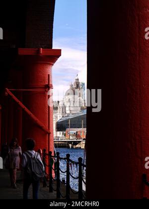 Das Liver Building, das durch die imposanten rot bemalten Säulen des renovierten Royal Albert Dock in Liverpool gesehen wird Stockfoto