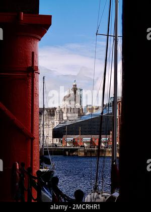 Das Liver Building, das durch die imposanten rot bemalten Säulen des renovierten Royal Albert Dock in Liverpool gesehen wird Stockfoto