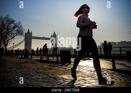 London, Großbritannien. 22. Januar 2023 Wetter in Großbritannien: Jogger am frühen Morgen passiert die Tower Bridge. Kredit: Guy Corbishley/Alamy Live News Stockfoto