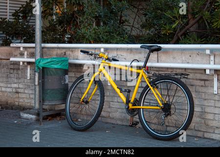 Fahrrad in der Stadt geparkt, an eine Bar gefesselt oder mit einem Vorhängeschloss gesichert, um zu verhindern, dass es gestohlen wird Stockfoto