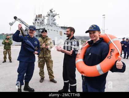 UCGC Oak (WLB 211) Befehlshaber LT. Commander. Jacob Loman eröffnet am 9. Juli 2022 ein Geschenk von Fulmar-Mitgliedern des französischen Marineschiffs bei einem Treffen in Nuuk, Grönland. USA Mitglieder der Küstenwache und aus Frankreich, Dänemark und Grönland trafen sich zu einem moralischen Ereignis am Ende der fünftägigen Übung Argus. USA Foto der Küstenwache von Petty Officer 2. Klasse Diana Sherbs. Stockfoto