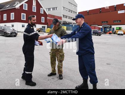 Der Kapitän des französischen Marineschiffs Fulmar stellt dem kommandierenden Offizier der USCGC Oak (WLB 211) einen Fähnrich vor. Jacob Loman während einer Begrüßungsveranstaltung in Nuuk, Grönland, 9. Juli 2022. USA Mitglieder der Küstenwache und aus Frankreich, Dänemark und Grönland trafen sich zu einem moralischen Ereignis am Ende der fünftägigen Übung Argus. USA Foto der Küstenwache von Petty Officer 2. Klasse Diana Sherbs. Stockfoto