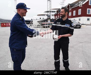 UCGC Oak (WLB 211) Befehlshaber LT. Commander. Jacob Loman überreicht dem Kapitän des französischen Marineschiffs Fulmar in Nuuk, Grönland, am 9. Juli 2022 eine Argus-Plakette. USA Mitglieder der Küstenwache und aus Frankreich, Dänemark und Grönland trafen sich zu einem moralischen Ereignis am Ende der fünftägigen Übung Argus. USA Foto der Küstenwache von Petty Officer 2. Klasse Diana Sherbs. Stockfoto