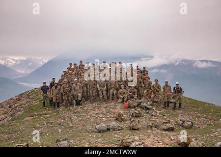 11. Soldaten der Airborne Division und Bergsteigerlehrer vom Northern Warfare Training Center posieren für ein Klassenfoto auf dem Gipfel einer 5000ft km langen Wanderung zum „Grassy Knoll“ während des Basic and Advanced Military Mountaineering Kurses am Black Rapids Training Site, 9. Juli. Der Zweck des 14-tägigen Kurses besteht darin, Soldaten darin zu trainieren, wie man sich durch bergiges Gelände manövriert, und dann zurück zu ihren Einheiten zu gehen und den Einheiten Soldaten zur Verfügung zu stellen, die in der Lage sind, das bergige Gelände von Alaska zu überqueren. (Foto von Staff Sgt. Christopher Dennis/11. Airborne Division Public Affairs NCO) Stockfoto