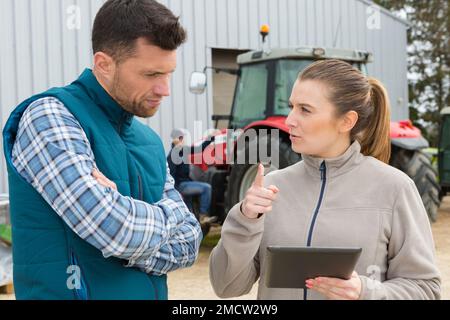 Zwei Bauern, die mit einem Tablet sprechen Stockfoto