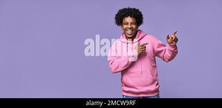 Ein glücklicher afroamerikanischer Teenager, der mit dem Finger zur Seite zeigt, um Werbung für neue Werbung zu machen. Stockfoto