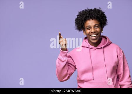 Ein glücklicher afrikanischer Teenager, der mit dem Finger nach oben zeigt und Promo präsentiert oder eine Idee hat. Stockfoto