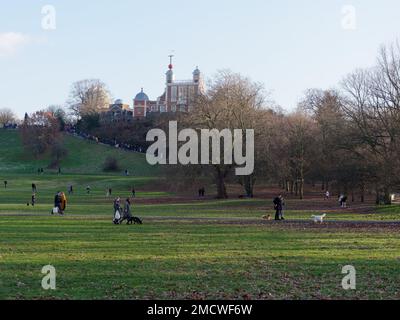 Wintertag im Greenwich Park, an dem die Menschen unter dem Royal Observatory spazieren gehen. London, England Stockfoto