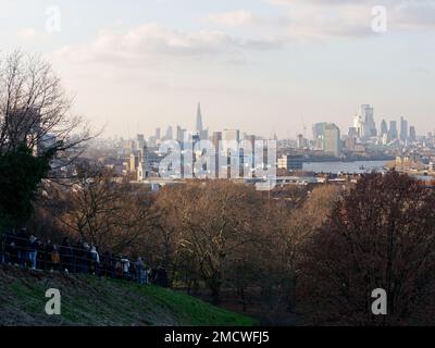 Blick vom Greenwich Park über die Themse mit The Shard dahinter, während die Leute den Hügel in der Nähe des Observatoriums aus dem Bild gehen. London, England. Stockfoto