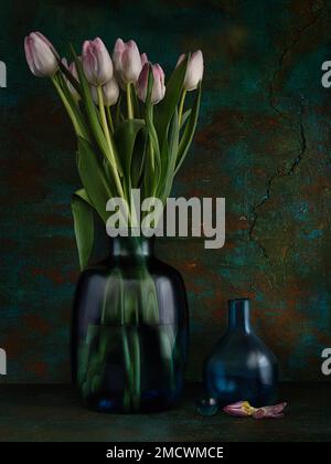 Stillleben mit Tulpen in Glasvase neben leerer Glasvase und Glaskugel, Studiofoto, Symbolfoto Stockfoto
