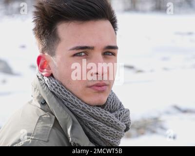 Junger Mann in den Bergen im Winter mit Schnee Stockfoto