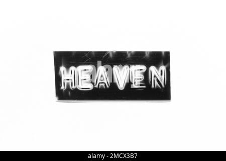 Schwarzes Banner mit geprägtem Buchstaben und Wort „Heaven“ auf weißem Papierhintergrund Stockfoto