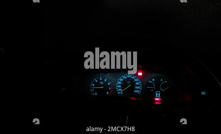 Nahaufnahme der roten und blauen Tachometer im Dunkeln der Nacht Stockfoto