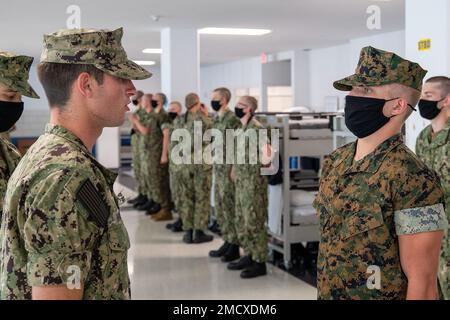 220711-N-ZW825-0178 GREAT LAKES, ILLINOIS (11. Juli 2022) Ein Naval Reserve Officers Training Corps (NROTC) New Student Indoctrination (NSI) Flottenkandidat beantwortet während einer Inspektion der Arbeitsuniform beim Recruit Training Command (RTC), Juli 11 eine Frage zu professionellem militärischen Wissen. Nach Abschluss des NSI beginnen die Kandidaten in diesem Herbst ihr erstes Jahr des NROTC-Programms an Hochschulen und Universitäten im ganzen Land. NSI ist ein Indoktrinierungsprogramm, das bei RTC ausgerichtet wird und den Fähnrich-Fähnrich eine gemeinsame militärische Ausbildung vermittelt. DIE NSI bietet Grundausbildung in fünf Fundam für die Kriegsführung an Stockfoto