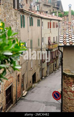 Mittelalterliche Straßenszene mit verschließenden Fenstern auf dreistöckigen Häusern entlang einer Passage, Bergdorf Roccatederighi, Toskana Italien, Stockfoto