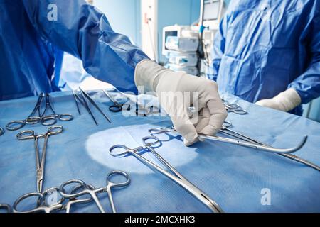 Nahaufnahme sterilisierter und gebrauchsfertiger chirurgischer Instrumente auf dem Tablett während der Operation im Operationssaal des Krankenhauses Stockfoto