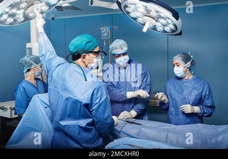 Team von Chirurgen und Krankenschwestern, die chirurgische Operationen im Krankenhaus-Operationssaal durchführen. Chirurgie Stockfoto